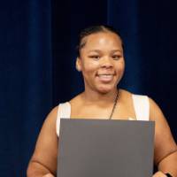 Smiling student holding a certificate